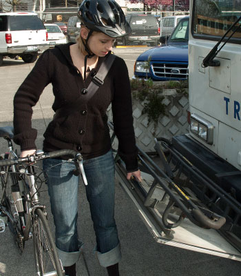 Photo of bicyclist placing bike on bus rack